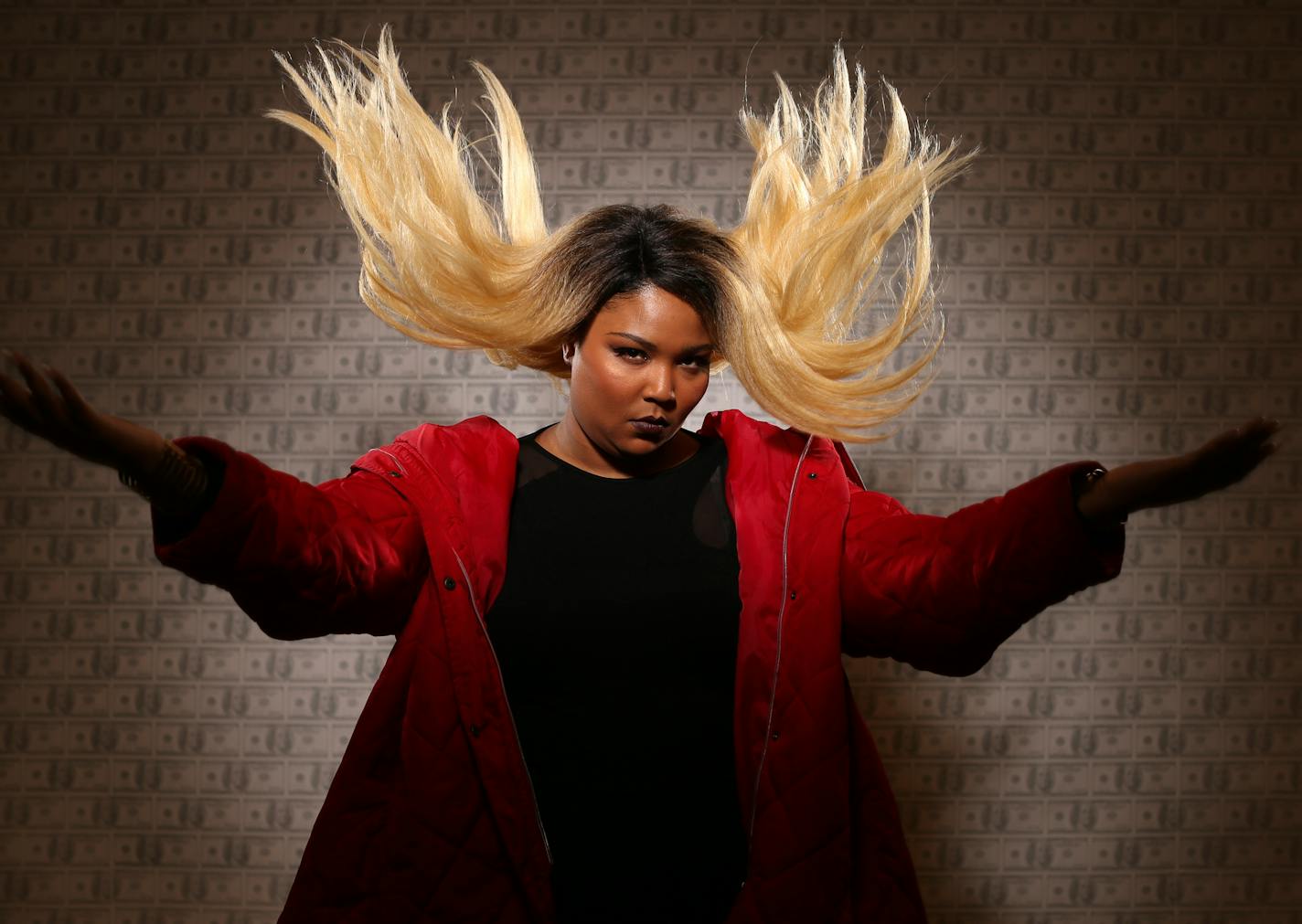 The singer Lizzo was photographed at the Minneapolis College of Art and Design before a show. The wallpaper backdrop is a student piece in the gallery titled "Cost of an MCAD education."