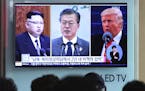 FILE - In this Wednesday, April 18, 2018, file photo, people watch a TV screen showing file footage of U.S. President Donald Trump, right, South Korea