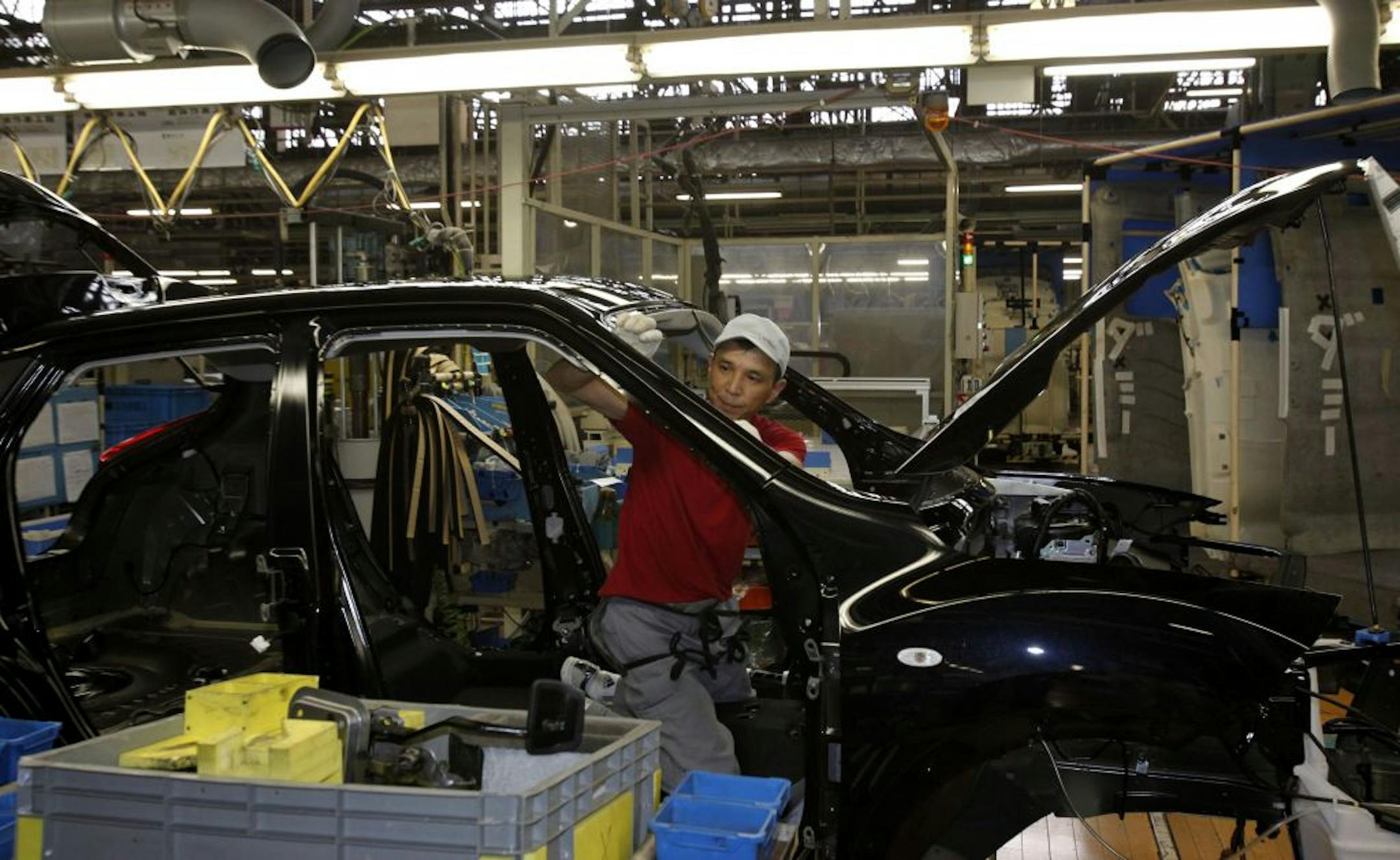 An employee for Nissan Motor Co. works on a car on the assembly line at the Japanese automaker's Oppama plant in Yokosuka near Tokyo, Saturday, July 2, 2011. Starting Saturday, Nissan and other Japanese automakers are working weekends and instead taking Thursday and Friday off for an aggressive nationwide effort to fight the power crunch created by the tsunami-crippled Fukushima Dai-ichi nuclear power plant.