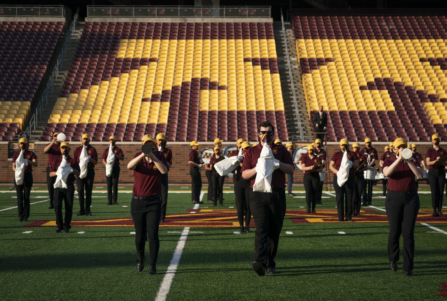 The University of Minnesota marching band wore masks with little holes for the mouth pieces of their instruments along with covers to prevent fine spray as they practiced and recorded their performances to be used at a later game at TCF Bank Stadium in Minneapolis, Minn., on Thursday, October 8, 2020. ] RENEE JONES SCHNEIDER renee.jones@startribune.com Champlin Park vs. Centennial in Circle Pines, Minn., on Thursday, October 8, 2020.