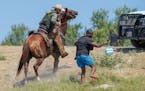 A U.S. Border Patrol agent on horseback tries to stop a Haitian migrant from entering an encampment on the banks of the Rio Grande near the Acuna Del 