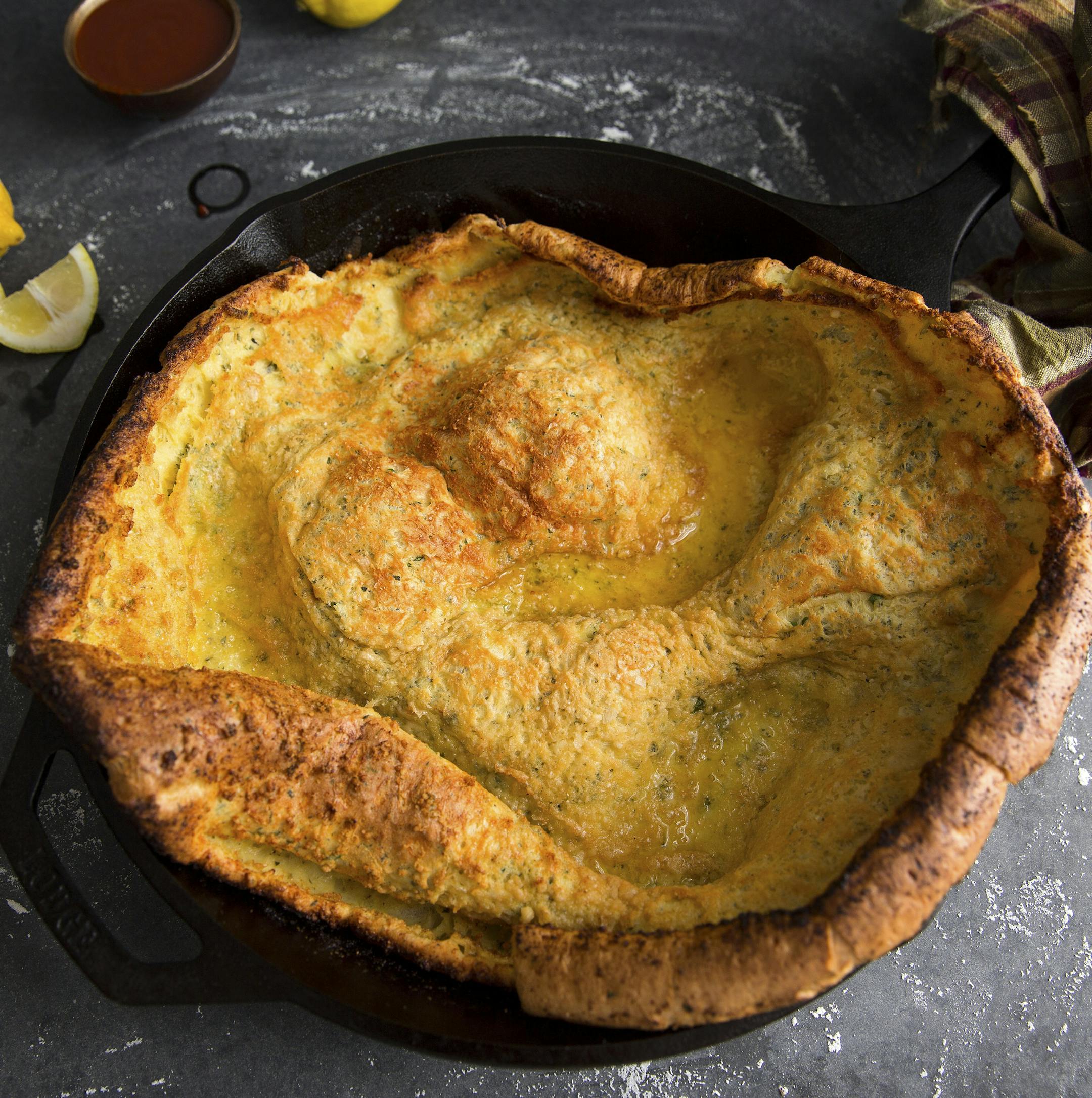 A savory Dutch baby — the big poufy pancake also known as a Dutch puff or German pancake, in New York, Sept. 13, 2015. This recipe turns the basic puffed pancake formula into something savory, cheesy, herby and peppery and is for those who prefer potato chips to cookies, the salty-toothed of the world. (Andrew Scrivani/The New York Times)