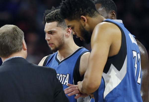 Minnesota Timberwolves guard Zach LaVine is helped off the court during the second half of the team's NBA basketball game against the Detroit Pistons,
