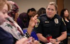 Officer Heidi Miller, right, with the Bloomington Police Department talked with participants of the New Americans Academy before giving a lecture on f
