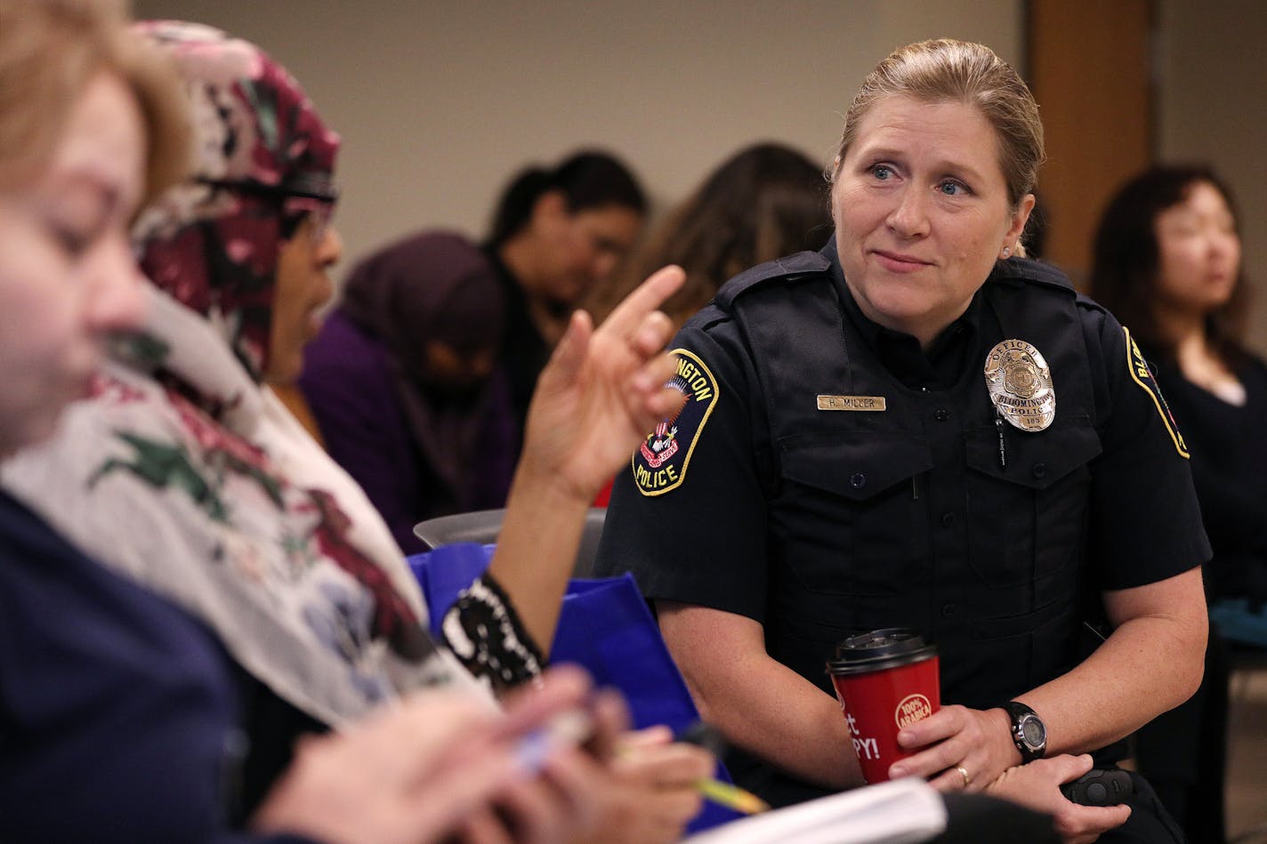 Officer Heidi Miller, right, with the Bloomington Police Department talked with participants of the New Americans Academy before giving a lecture on fraud prevention Wednesday. ] ANTHONY SOUFFLE &#xef; anthony.souffle@startribune.com Bloomington Police and other law enforcement agencies hosted a graduation from the New Americans Academy, a seven-week course which teaches immigrants how to interact with police, fraud and fire prevention, tenants' rights and other issues Wednesday, April 26, 2017