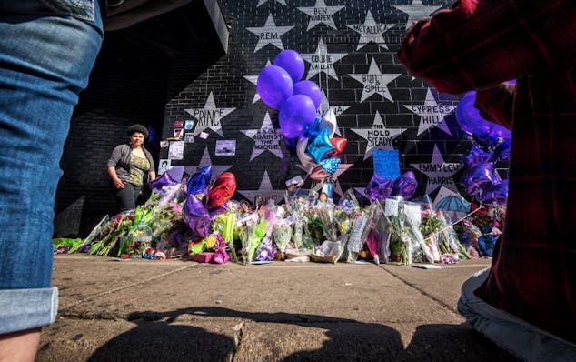 People filed past the makeshift memorial next to Prince's star on First Avenue's wall of stars. They took photos and posed for their own, left letters