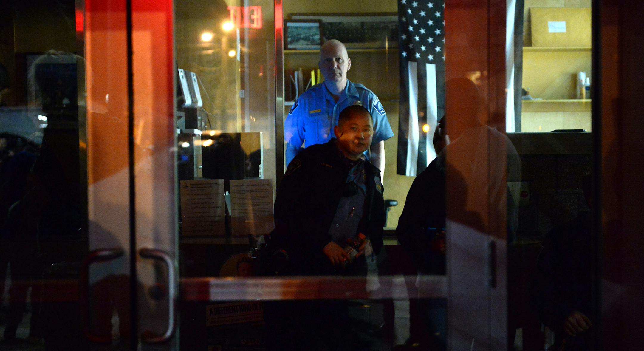 A police oficer watched the protesters outside the Fourth Precinct Monday evening.