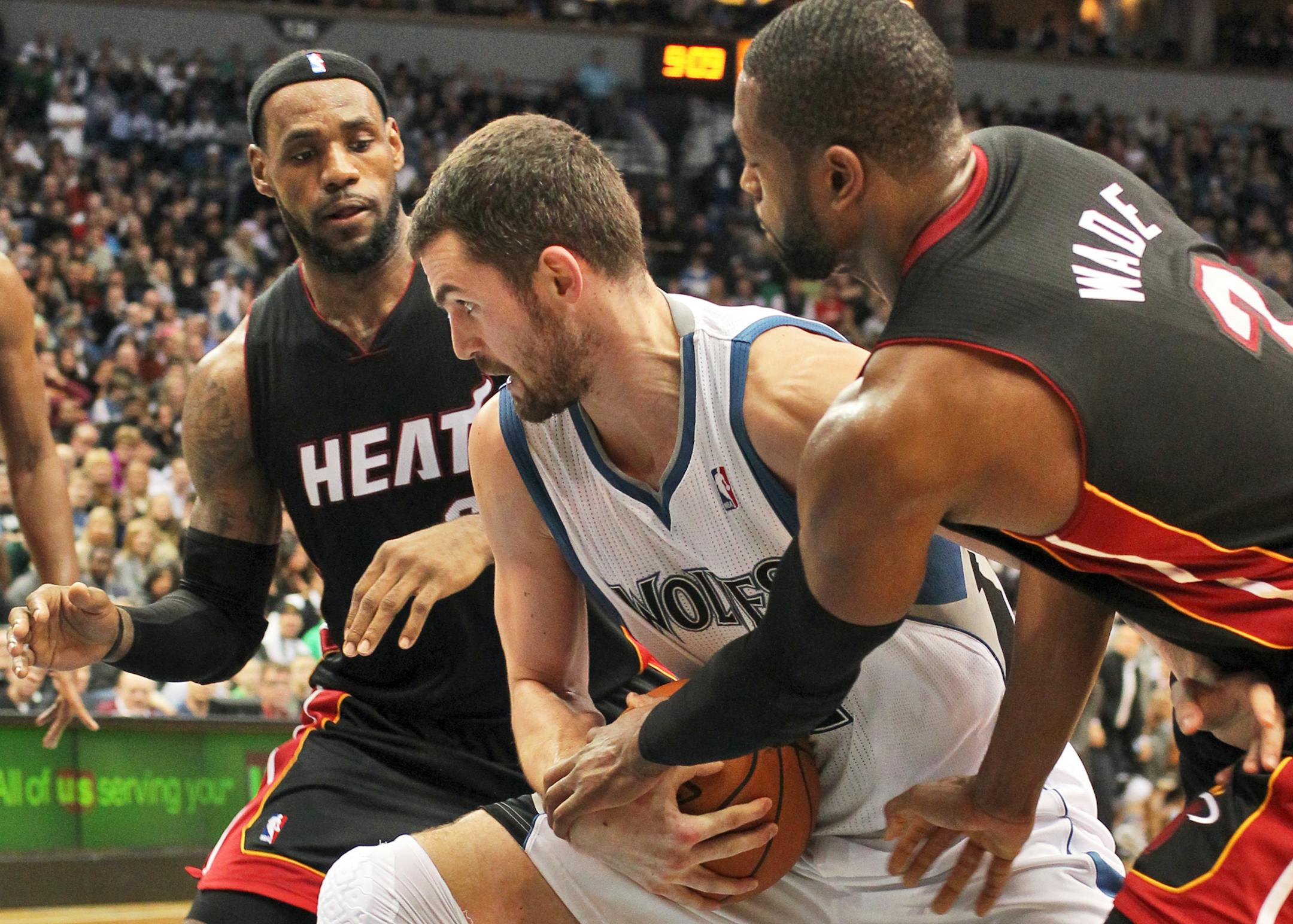 Destined to play together? In this 2011 file photo, Kevin Love of the Minnesota Timberwolves fights for the ball against LeBron James, left, then with the Miami Heat, and Dwayne Wade.