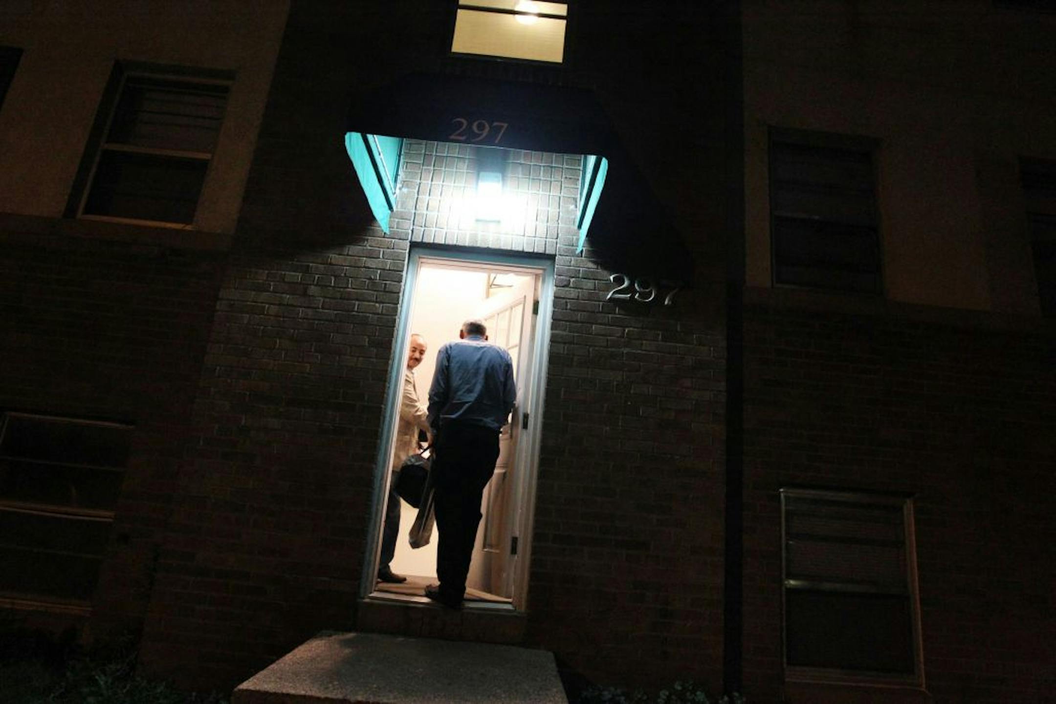 Just before midnight, Mesfin Tsegay, left, case manager with the International Institute of Minnesota, takes Iraq refugee Kareem Al Jaber to his new apartment in St. Paul May 24, 2012. Tsegay carried with him a hot meal to leave with Al Jaber on his first night alone in his new country.