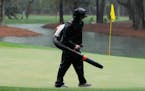 A course worker cleans the green on the 15th hole during a weather delay in the final round of the RBC Heritage on Sunday in Hilton Head Island, S.C.