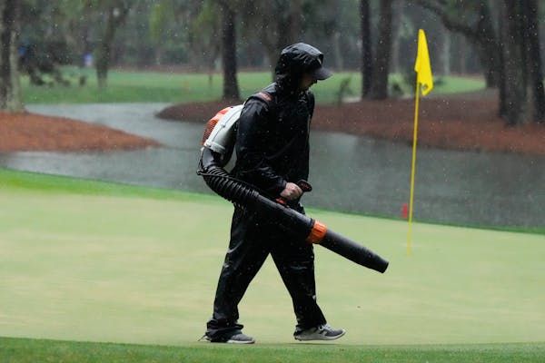 A course worker cleans the green on the 15th hole during a weather delay in the final round of the RBC Heritage on Sunday in Hilton Head Island, S.C.