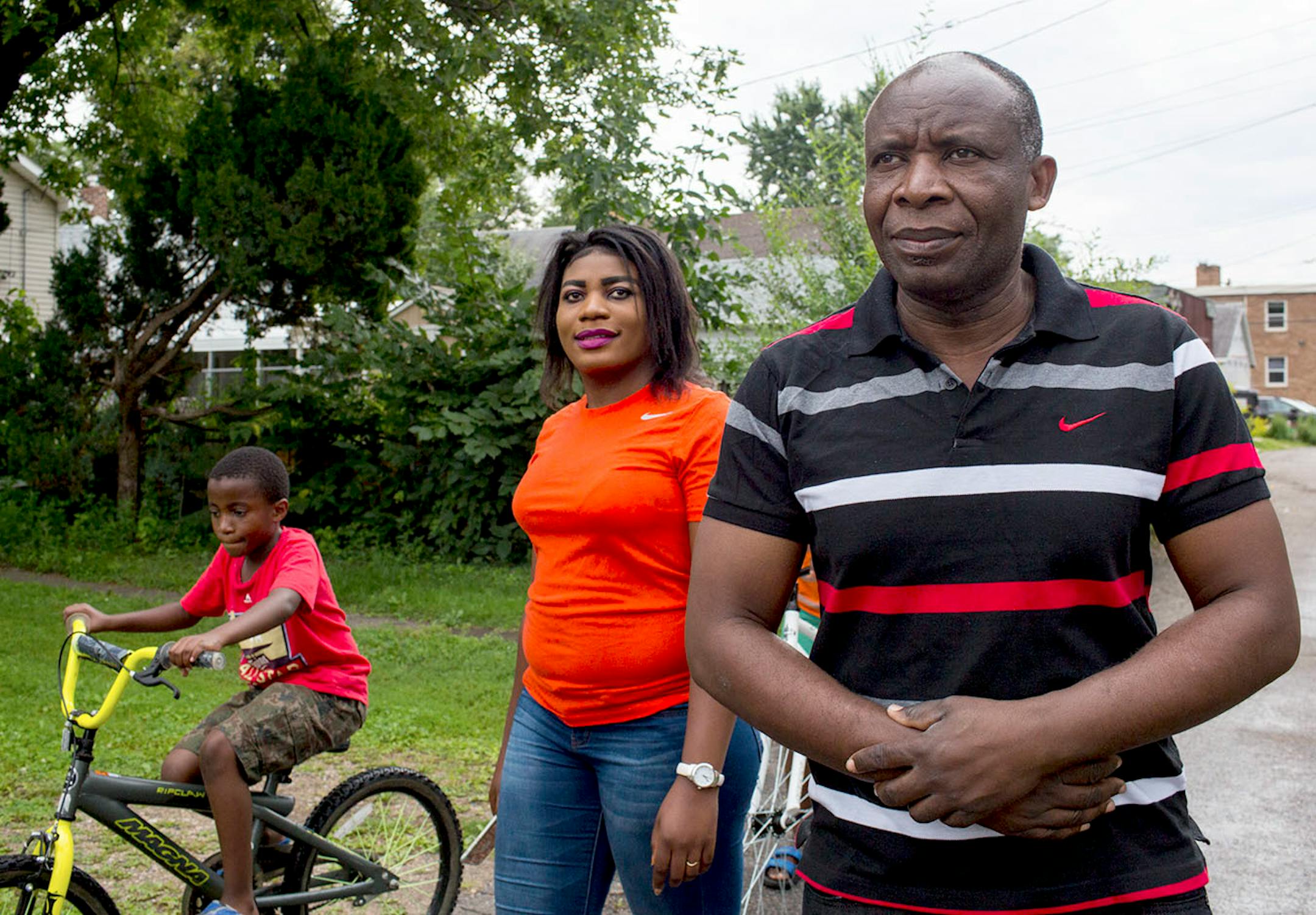 Ladislas Mihigo (right) looks ahead during a family walk around the block with Bonney (left) and Lydia Mihigo near their St. Paul home, on Sunday afternoon.
