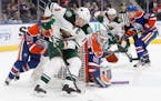 Minnesota Wild's Mikko Koivu (9) controls the puck as Edmonton Oilers' goalie Jonas Gustavsson (50) looks for the shot during the first period of an N