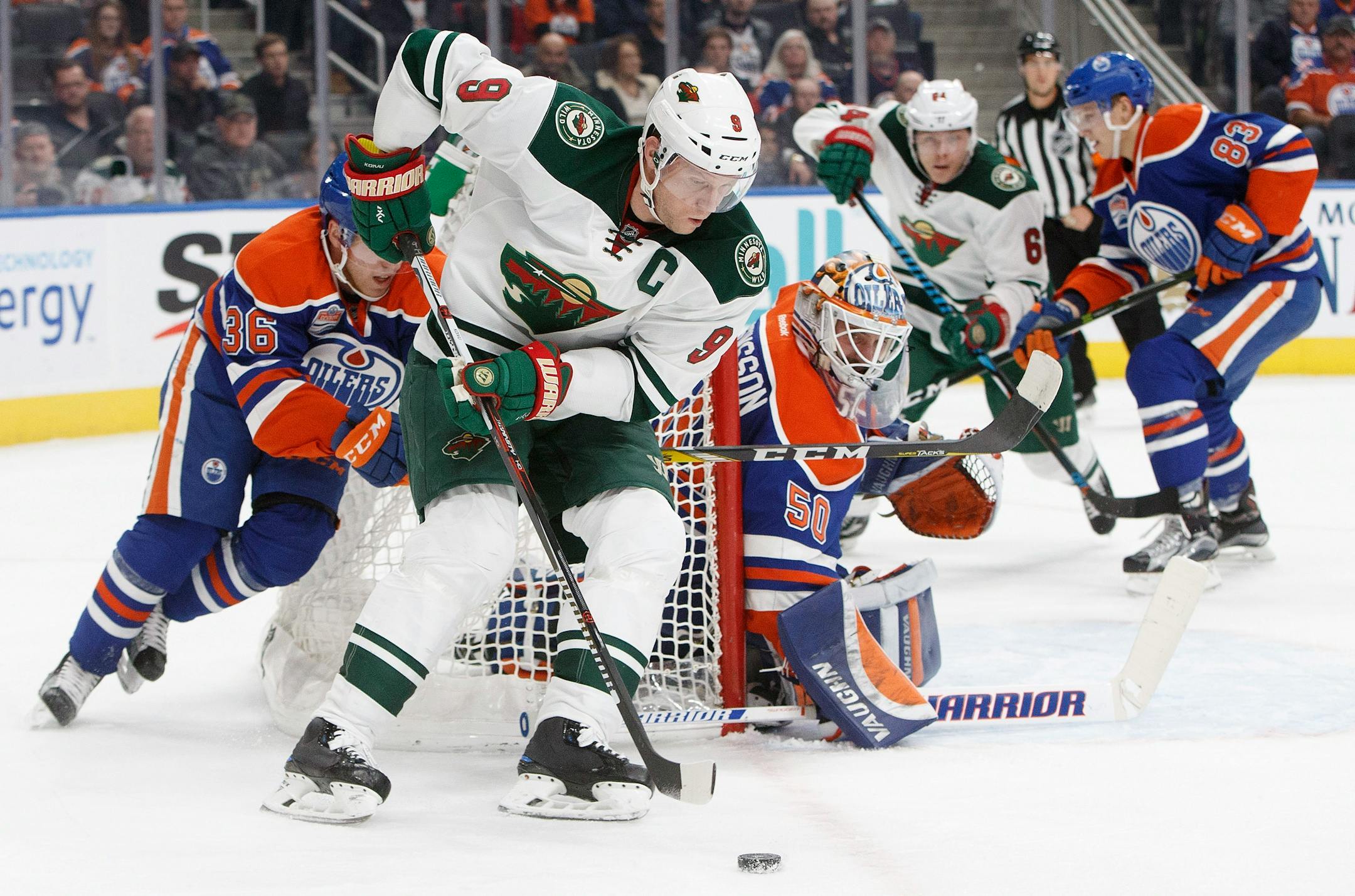 Minnesota Wild's Mikko Koivu (9) controls the puck as Edmonton Oilers' goalie Jonas Gustavsson (50) looks for the shot during the first period of an NHL hockey game in Edmonton, Alberta, Sunday, Dec. 4, 2016. (Jason Franson/The Canadian Press via AP)