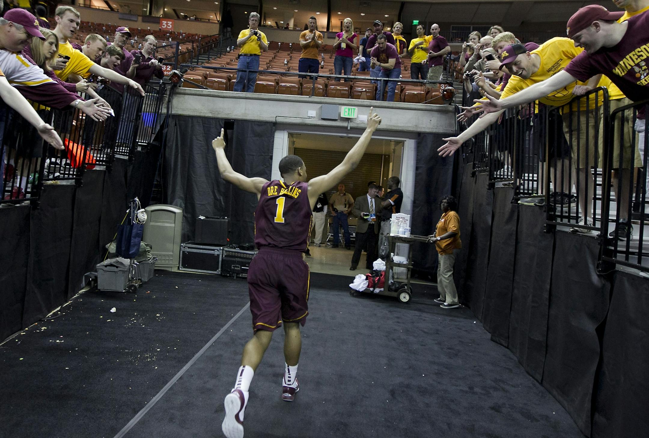 Minnesota's Andre Hollins waves to fans as he leaves the floor after the Gophers defeated UCLA