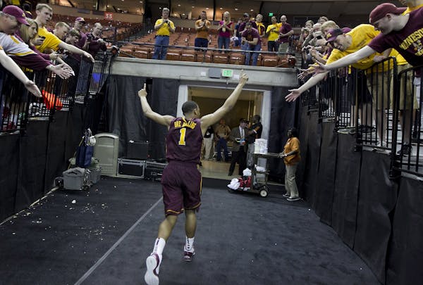 Minnesota's Andre Hollins waves to fans as he leaves the floor after the Gophers defeated UCLA
