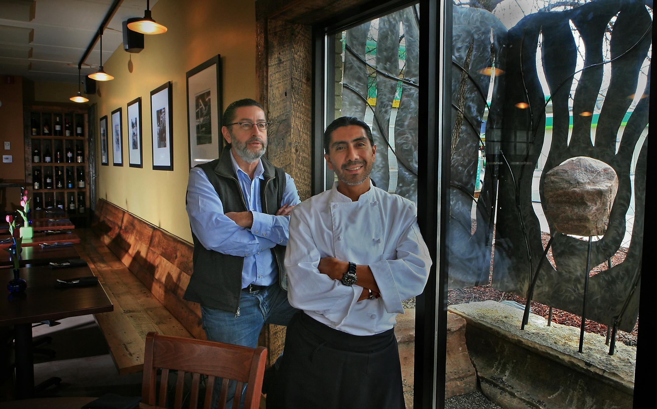 Dave Kopfmann, left, and chef/co-owner Juan Juarez Garcia stand in their La Chaya Bistro on Nicollet Av. Kopfmann, owner of a landscape company, Yardscapes, did all the outside landscaping and designed the fence and sculptures.