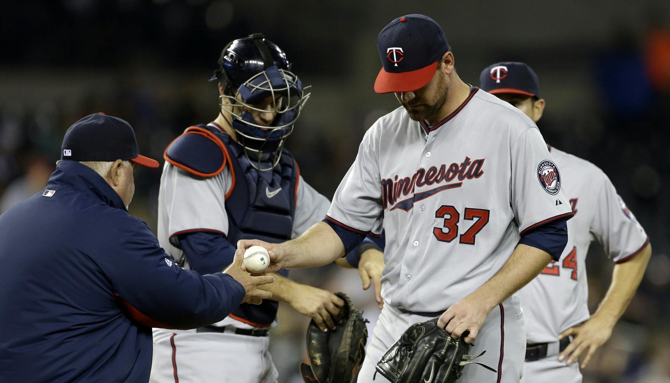 Minnesota Twins starting pitcher Mike Pelfrey (37) gives the ball to manager Ron Gardenhire during the sixth inning of a baseball game against the Detroit Tigers in Detroit, Monday, April 29, 2013. (AP Photo/Carlos Osorio)