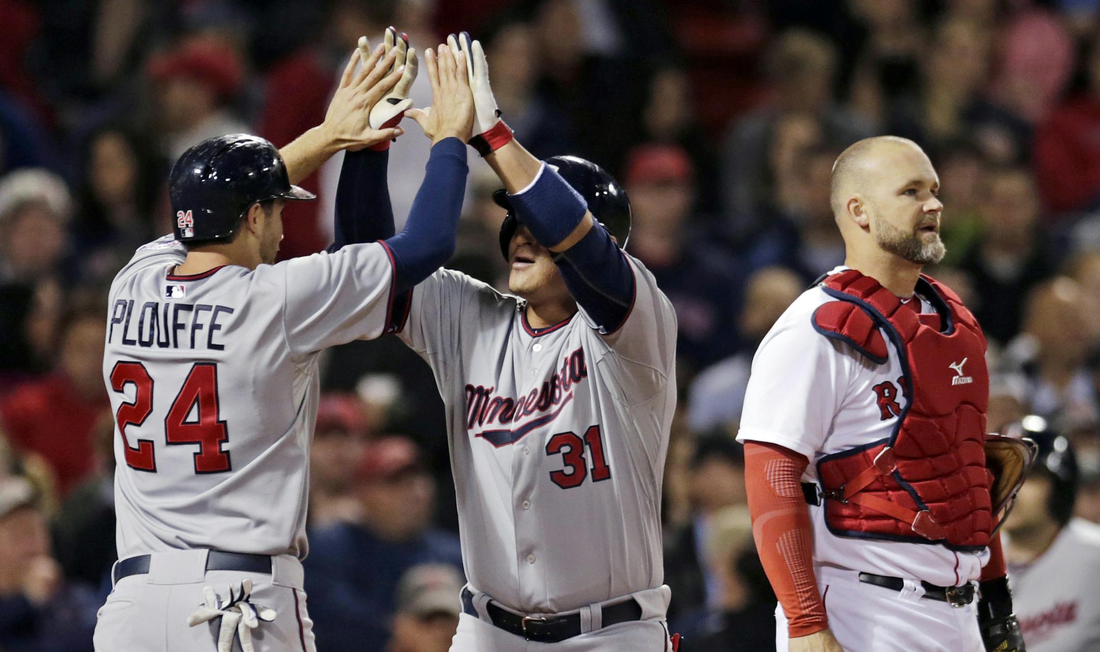 Minnesota Twins' Oswaldo Arcia (31) is congratulated by Trevor Plouffe after his two-run, home run during the sixth inning of a baseball game at Fenway Park in Boston, Thursday, May 9, 2013. At right is Boston Red Sox catcher David Ross. (AP Photo/Charles Krupa) ORG XMIT: MIN2013050920493576