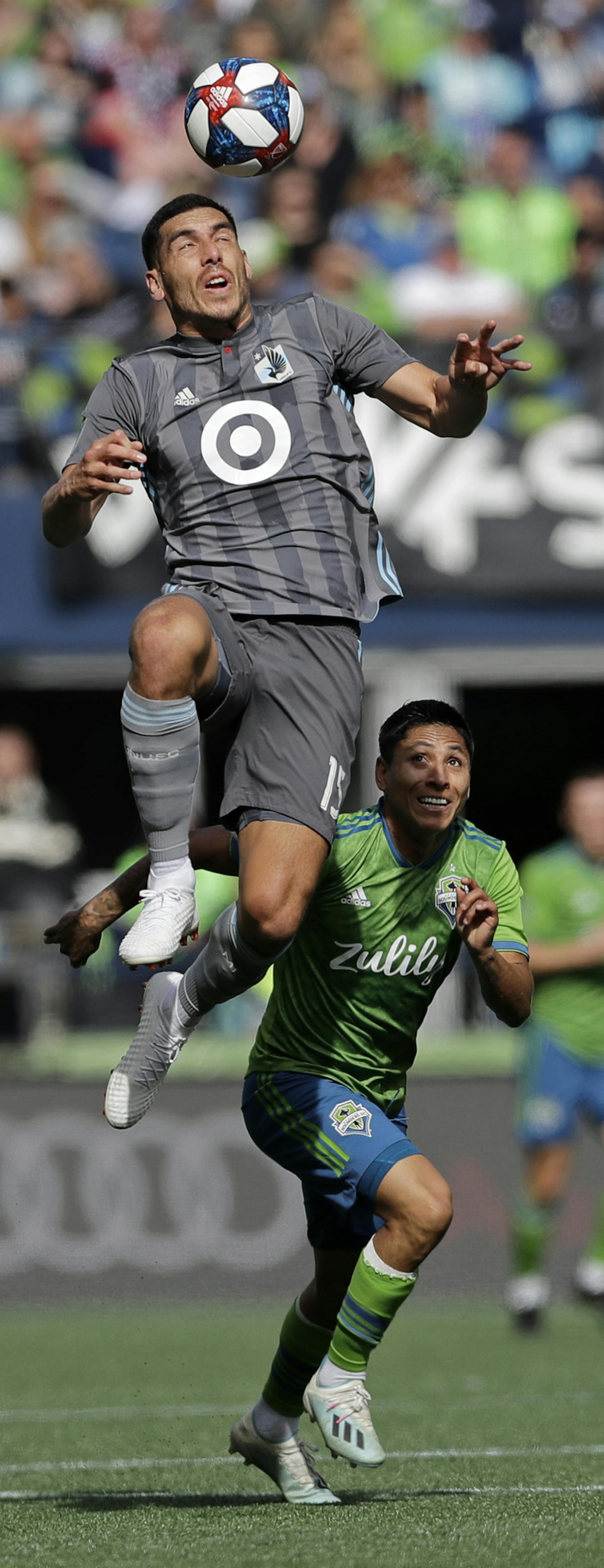 Minnesota United defender Michael Boxall, left, heads the ball above Seattle Sounders forward Raul Ruidiaz, second from left, during the first half of an MLS soccer match, Sunday, Oct. 6, 2019, in Seattle (AP Photo/Ted S. Warren)