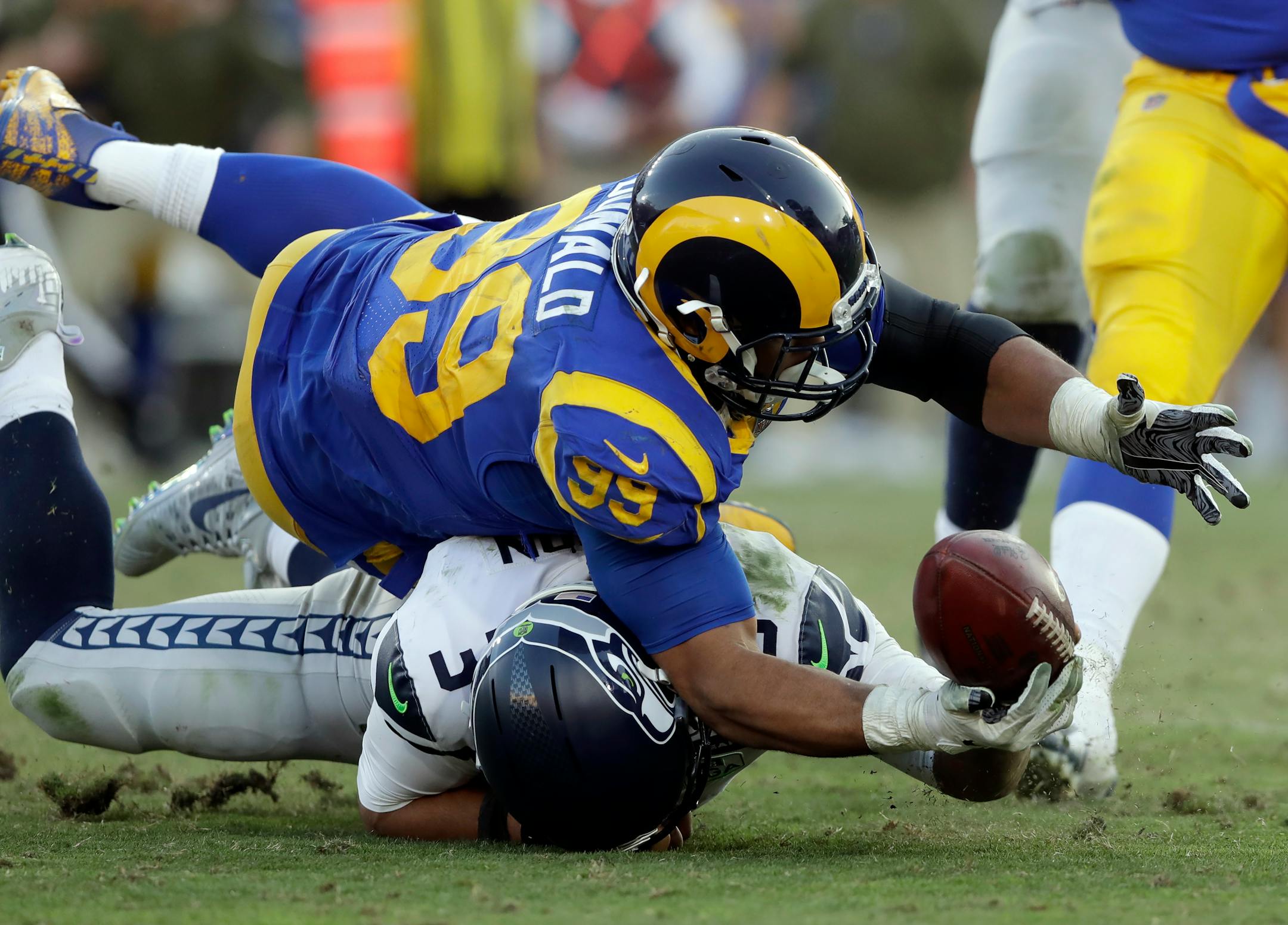Seahawks quarterback Russell Wilson battles Rams defensive end Aaron Donald for a ball Wilson lost on a fumble in Week 10.
