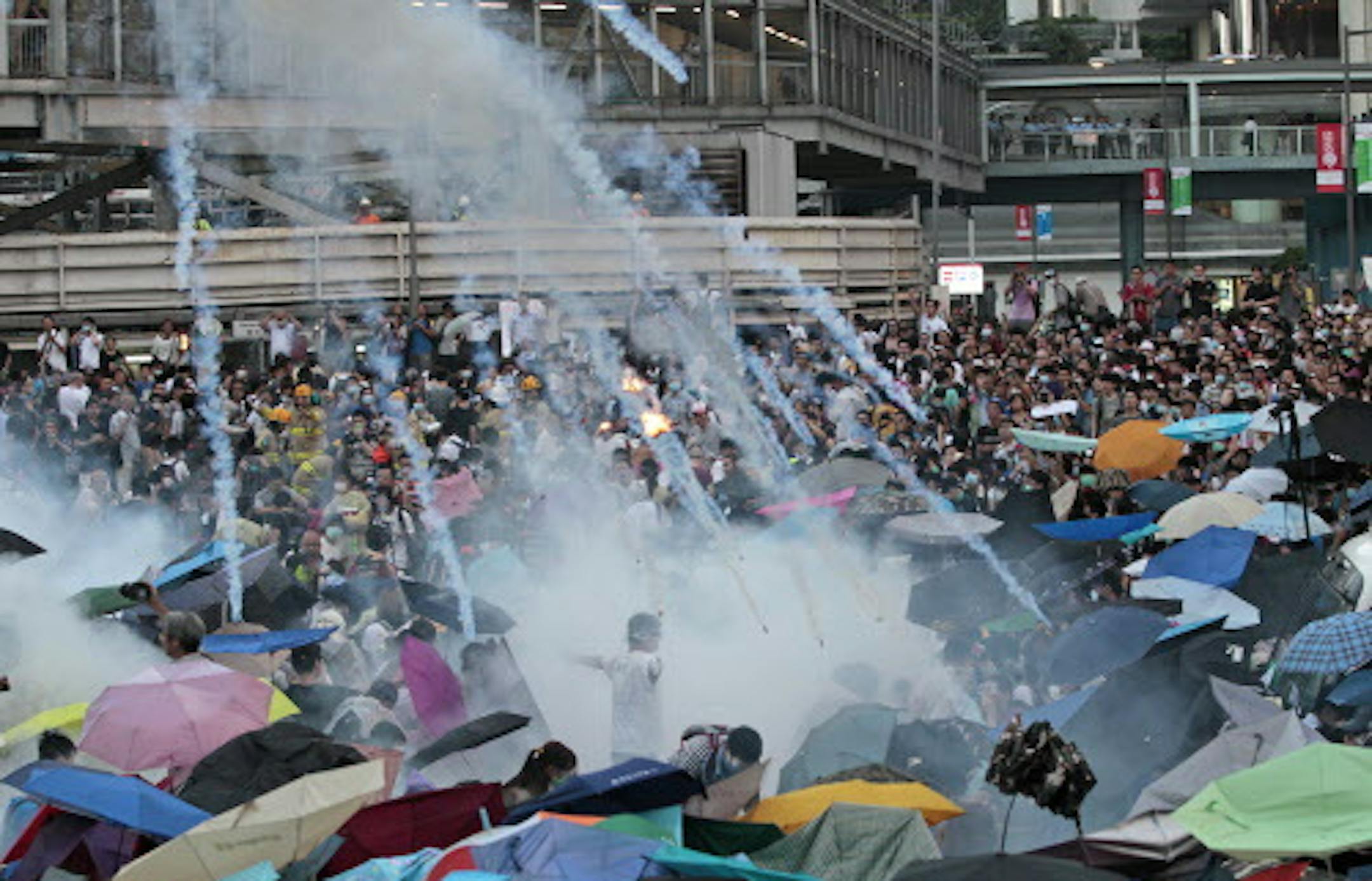 Riot police launch tear gas into the crowd as thousands of protesters surround the government headquarters in Hong Kong Sunday, Sept. 28, 2014. Hong Kong police used tear gas on Sunday and warned of further measures as they tried to clear thousands of pro-democracy protesters gathered outside government headquarters in a challenge to Beijing over its decision to restrict democratic reforms for the city. (AP Photo/Wally Santana)