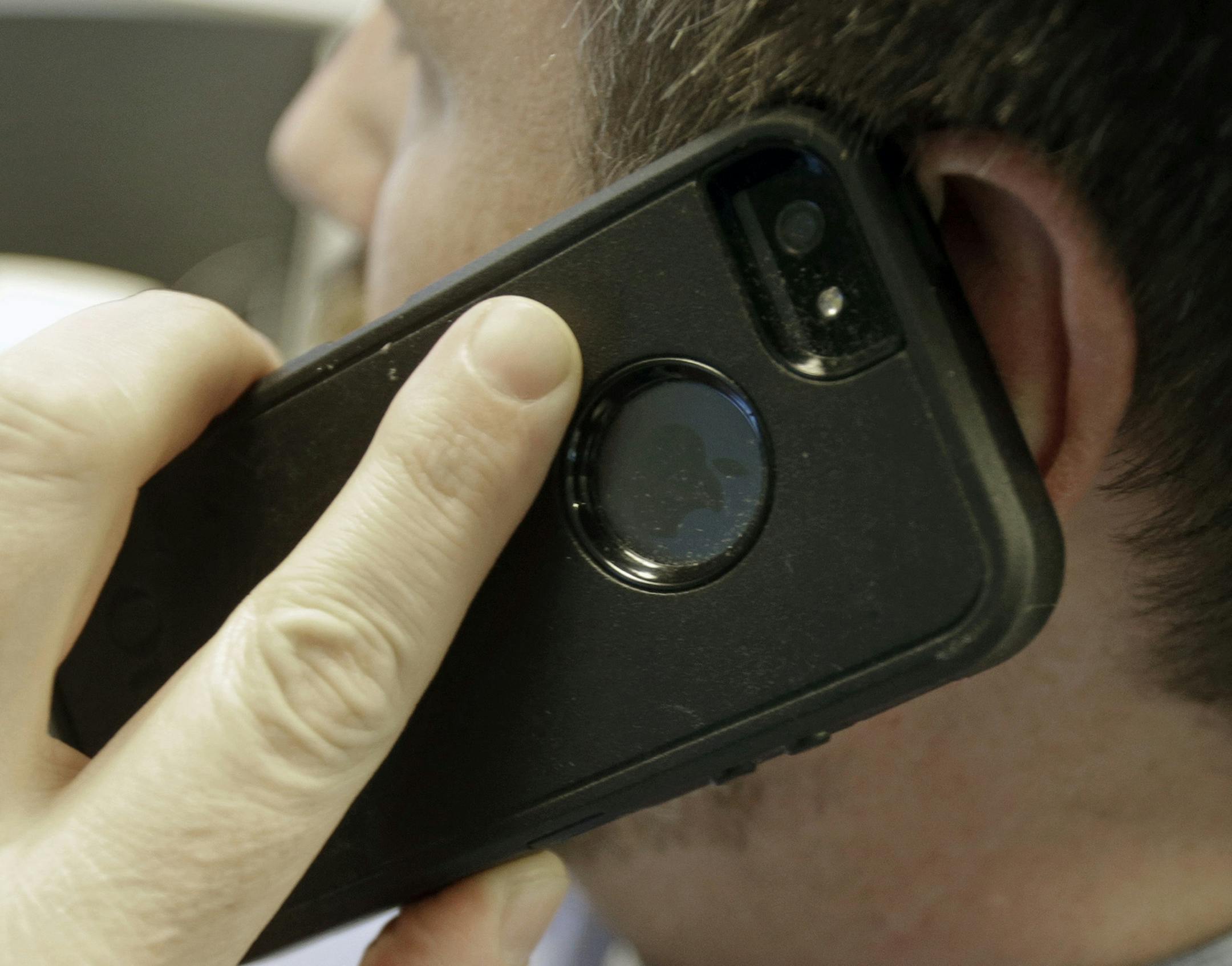 A man poses holding his cell phone Monday, Jan. 13, 2014, in Minneapolis. Lawmakers in the Minnesota House face a pre-filing deadline for bills ahead of the 2014 legislative session. A lawmaker is seeking a bill to require that providers include a "kill switch" to remotely disable lost or stolen phones. (AP Photo/Jim Mone) ORG XMIT: MIN2014021317040748