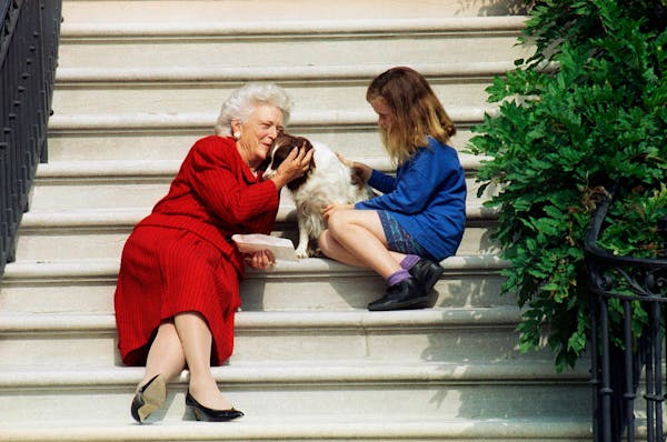 First Lady Barbara Bush, her granddaughter Barbara, and dog Millie waited on the steps of the White House for U.S. President George H.W. Bush in 1991.