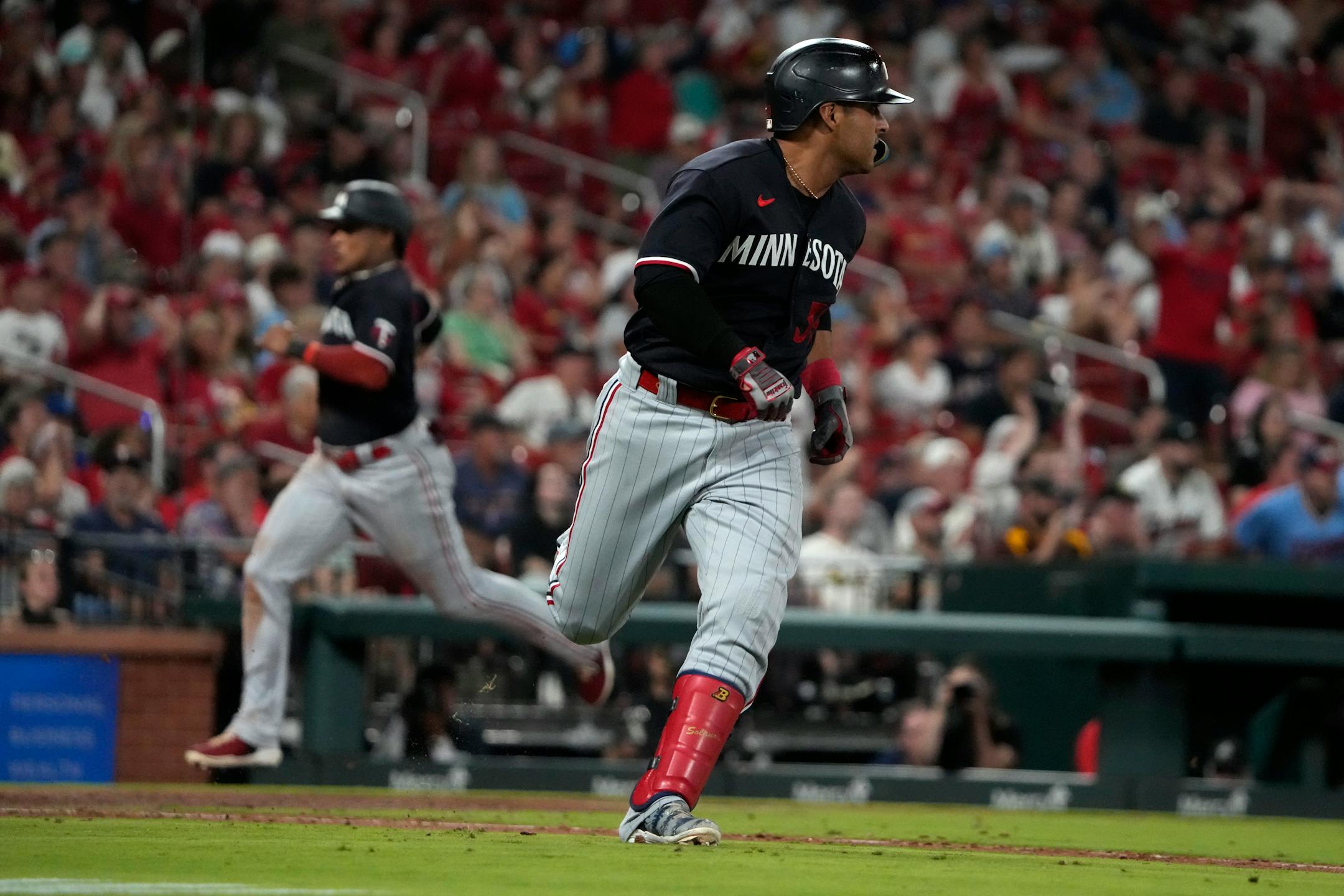 RETRANSMISSION TO CORRECT FROM DOUBLE TO SINGLE - Minnesota Twins' Donovan Solano rounds first on a two-run single as teammate Jorge Polanco comes in to score during the seventh inning of a baseball game against the St. Louis Cardinals Tuesday, Aug. 1, 2023, in St. Louis. (AP Photo/Jeff Roberson)