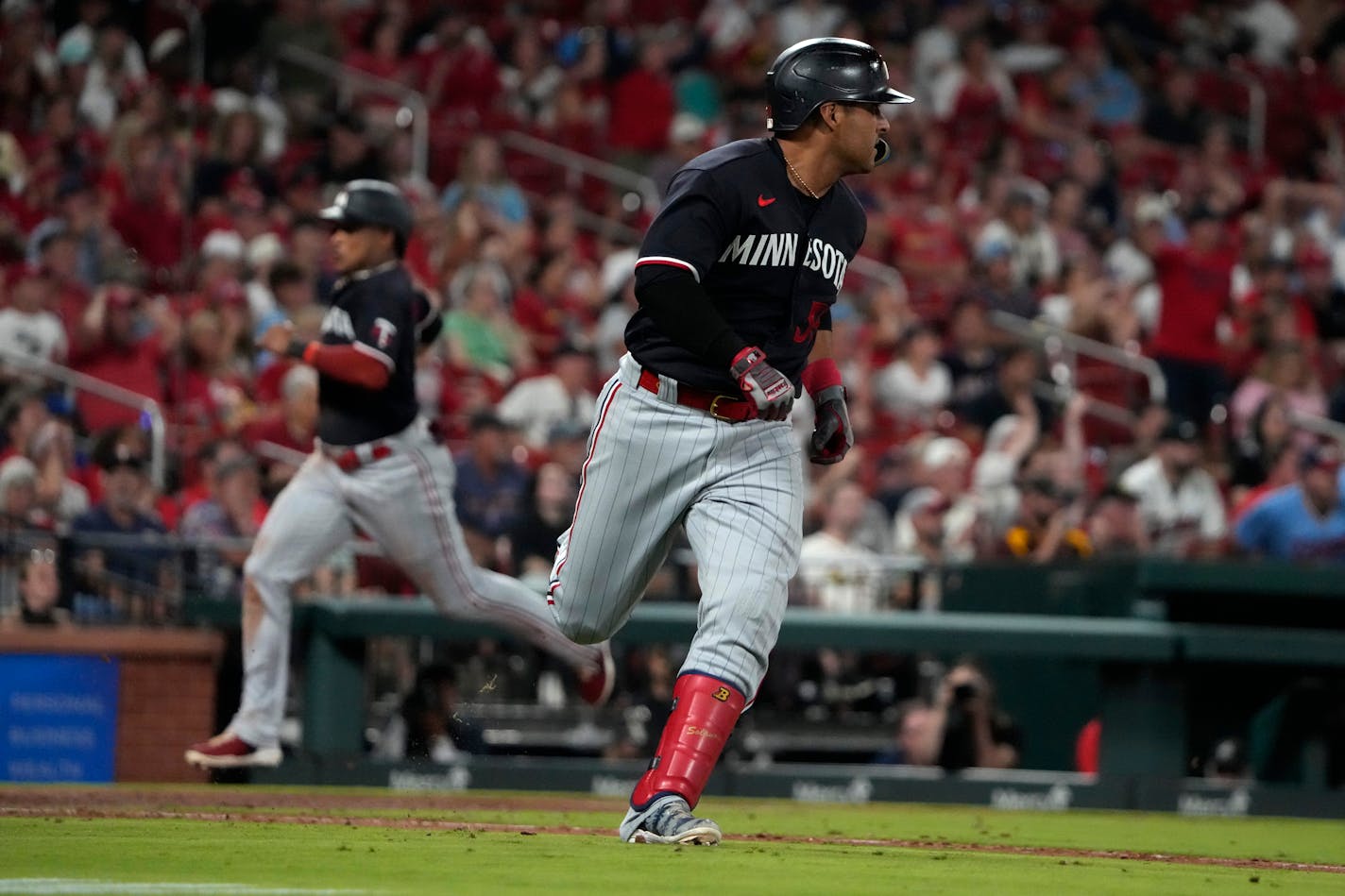 RETRANSMISSION TO CORRECT FROM DOUBLE TO SINGLE - Minnesota Twins' Donovan Solano rounds first on a two-run single as teammate Jorge Polanco comes in to score during the seventh inning of a baseball game against the St. Louis Cardinals Tuesday, Aug. 1, 2023, in St. Louis. (AP Photo/Jeff Roberson)