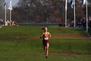 With no other runner visible, Forest Lake junior Norah Hushagen (232) pulls far ahead of the pack as she finishes the home stretch to win the Class 3A