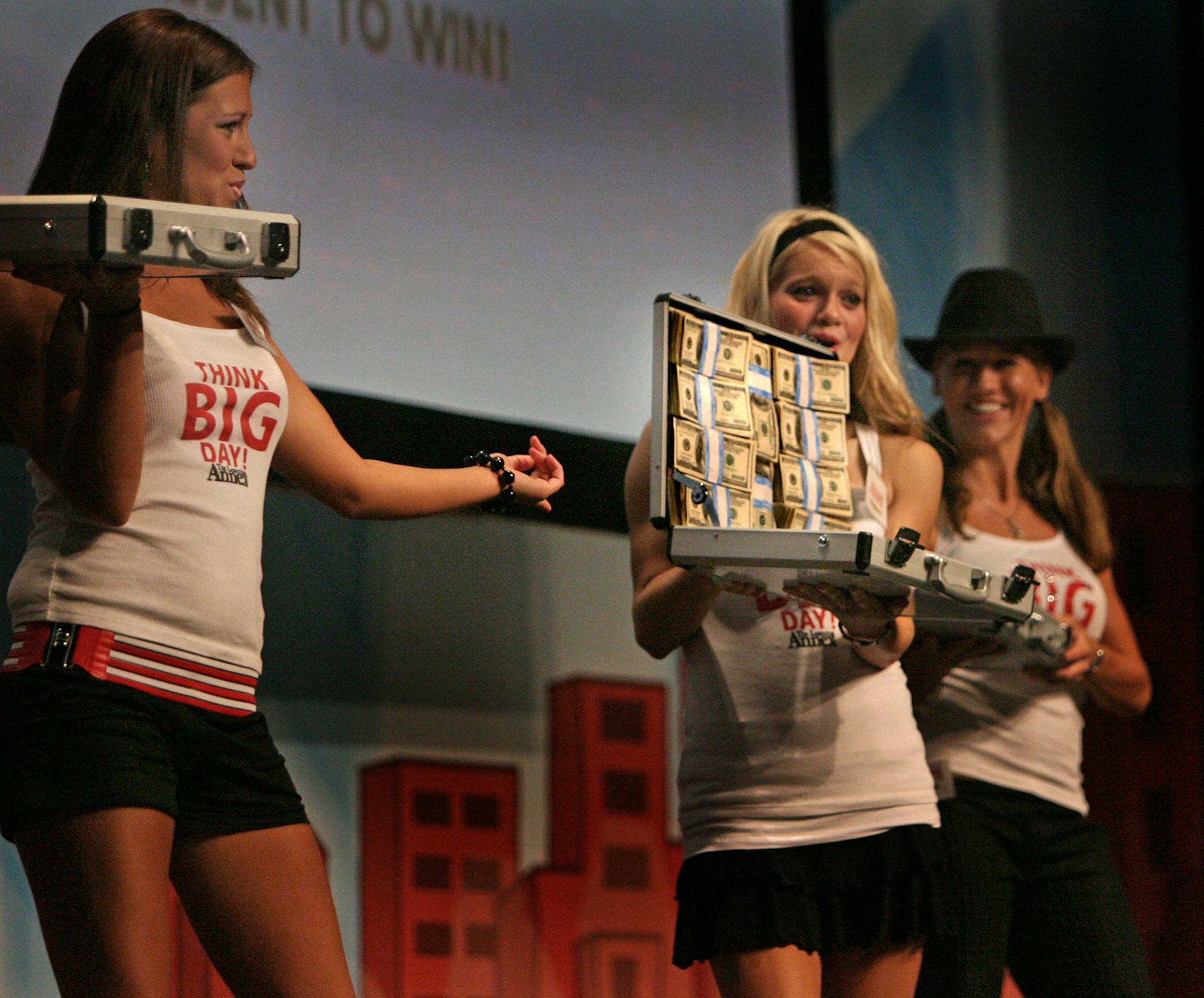 Women parade the stage holding briefcases filled with money to be given away at the Learning Annex Think Big Day at the Minneapolis Convention Center in 2006. Donald Trump and George Foreman spoke at the event.
