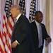 Former Republican presidential candidate Ben Carson, right, walks past Republican presidential candidate Donald Trump, left, after announcing he will 