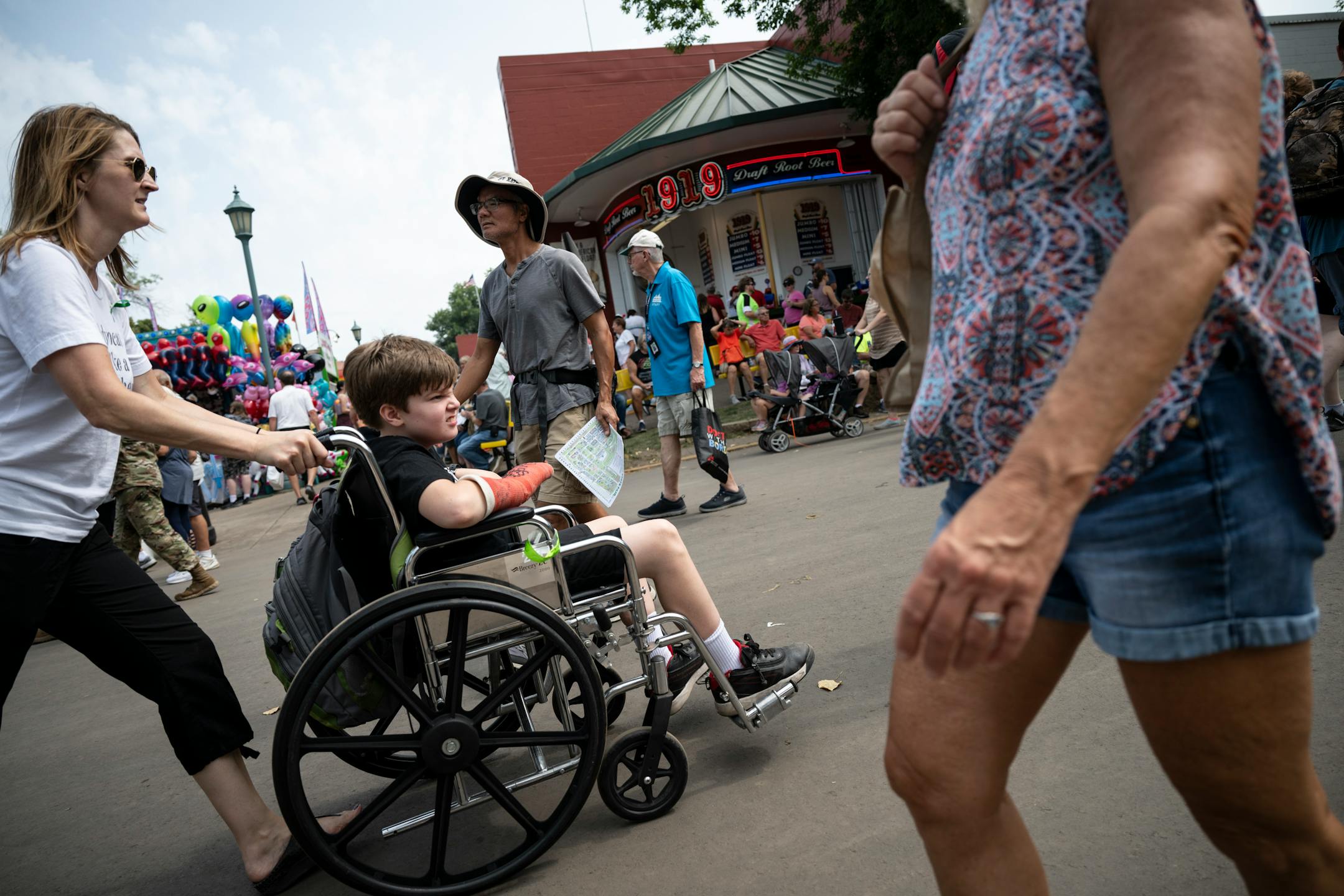 Sara St. Louis pushes her 12-year old son Ezra, who suffered a TBI, around the fair.