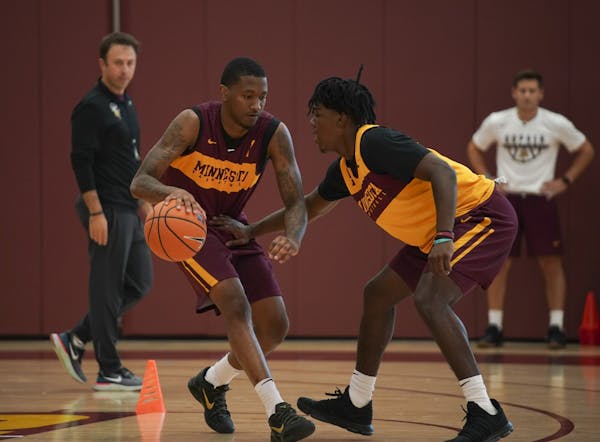Dupree McBrayer, left, and Marcus Carr took part in a drill during practice Tuesday afternoon while head coach Richard Pitino observed.