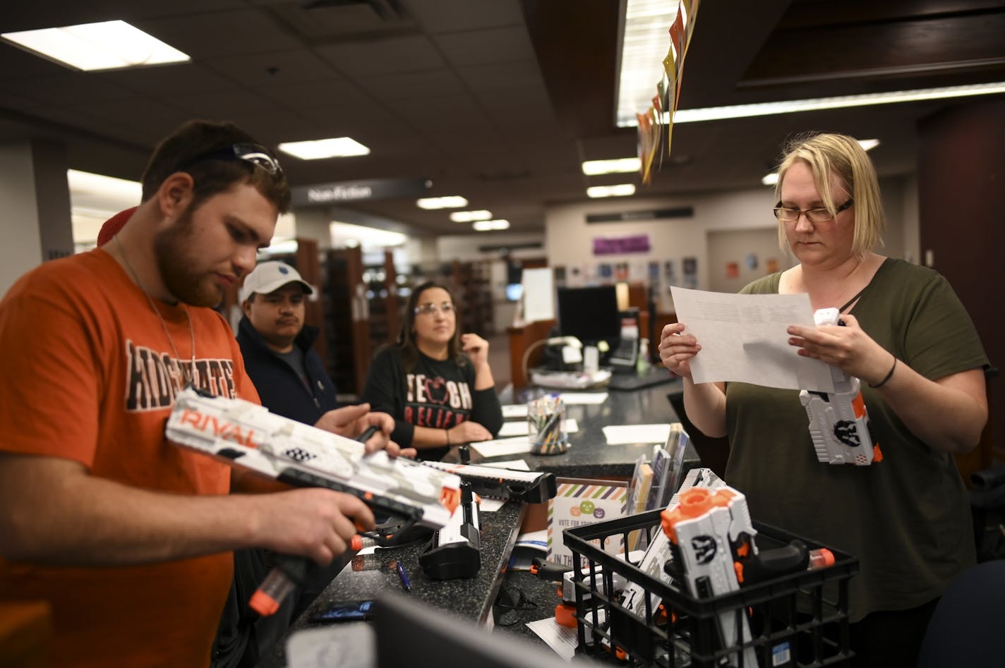 Nick Vanderkooi, left, a student at Ridgewater College, checked out his NERF gun as Syrena Maranell, Willmar Public Library's adult services librarian, looked at the RSVP list for Friday night's NERF wars.