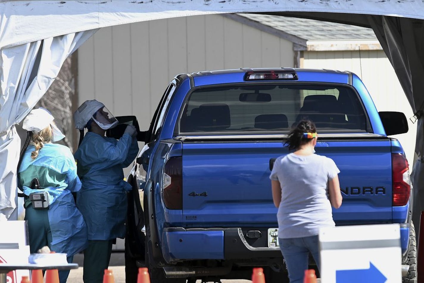 In this Saturday, April 18, 2020, photo, medical workers administer drive-up COVID-19 tests outside the Sanford Worthington Clinic in Worthington, Minn.