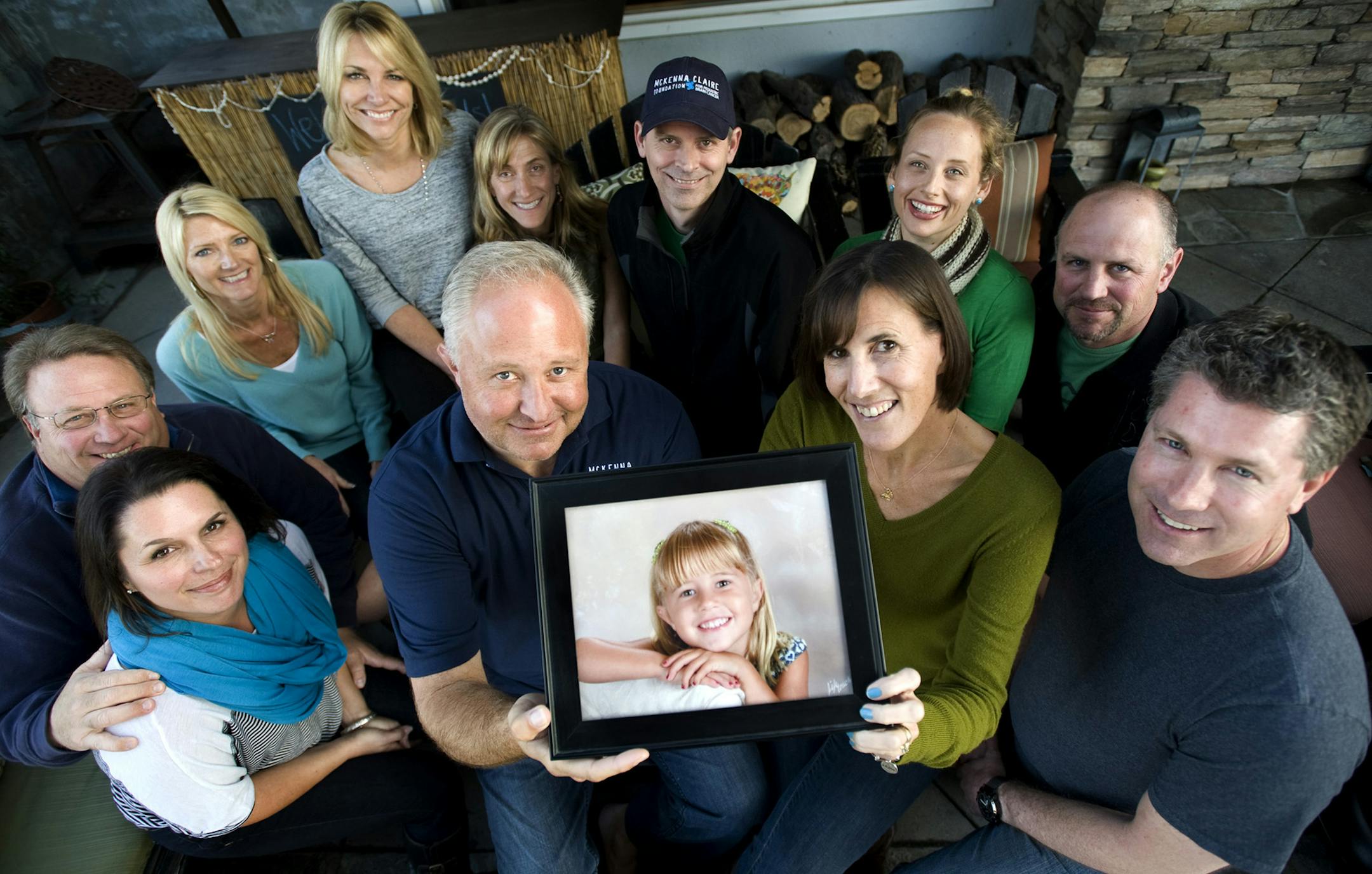 finding meaning in death: Dave and Kristine Wetzel, holding a photo of their daughter, McKenna, are surrounded by members of the McKenna Claire Foundation. McKenna died in July 2011, just six months after being diagnosed with a rare brain cancer. The foundation supports research that uses cells from her tumor.