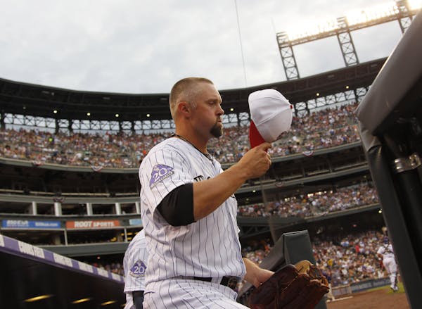 Colorado Rockies right fielder Michael Cuddyer dons his cap and heads to his position to face the Los Angeles Dodgers in the first inning of the Rocki