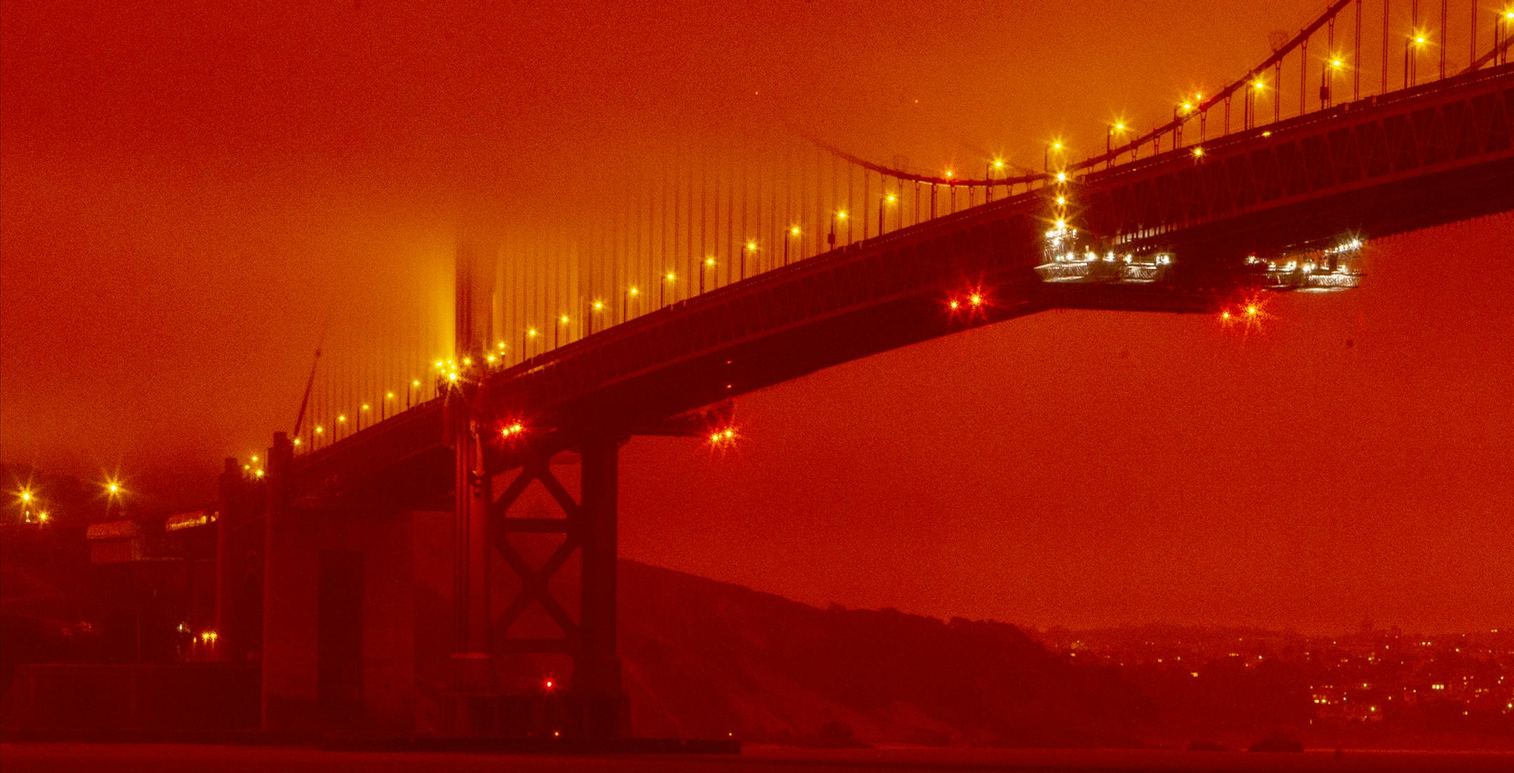 In this photo provided by Frederic Larson, the Golden Gate Bridge is seen at 11 a.m. PT, Wednesday, Sept. 9, 2020, in San Francisco, amid a smoky, orange hue caused by the ongoing wildfires. (Frederic Larson via AP)