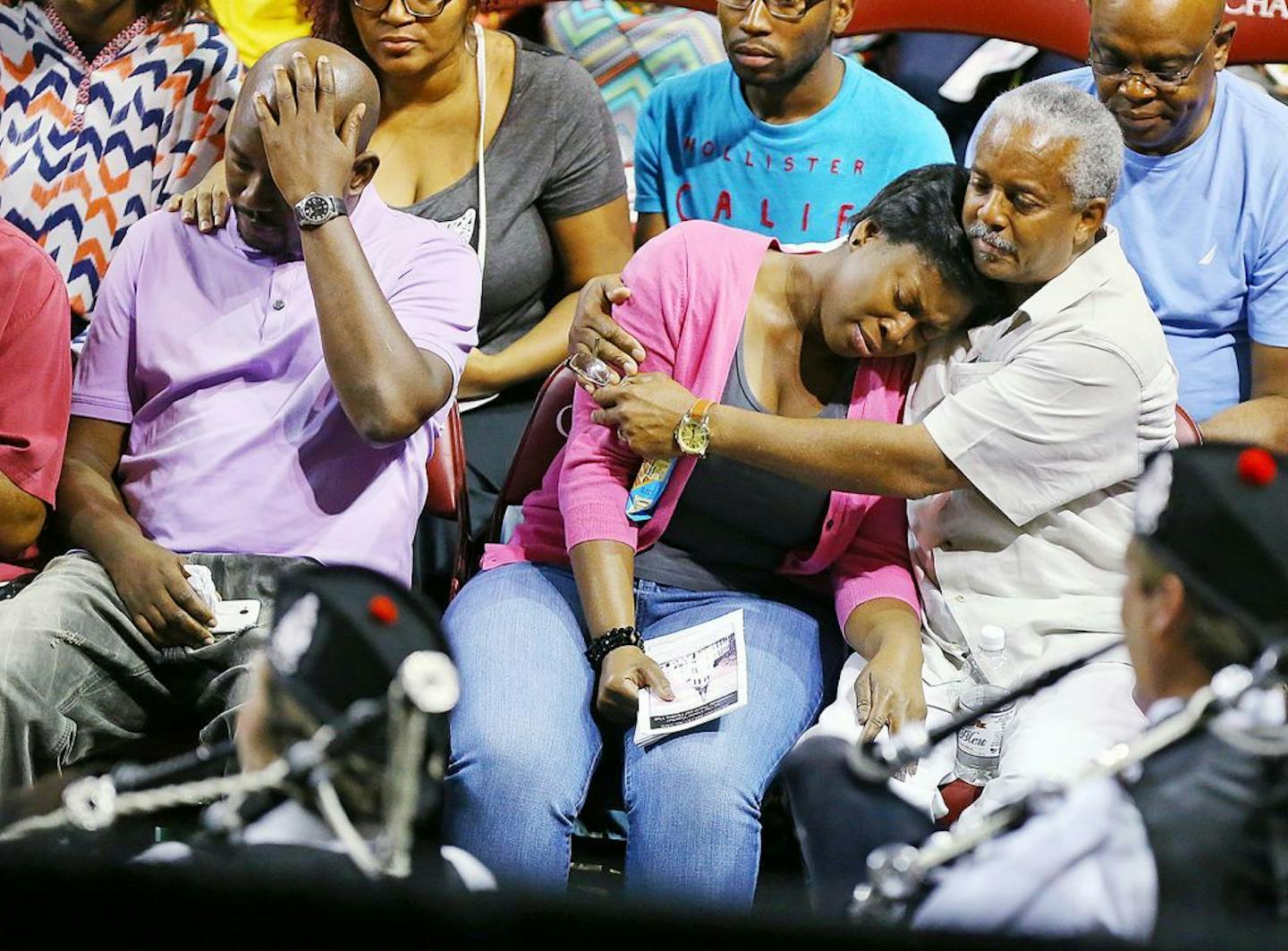 Family members of the shooting victims react as the Charleston Pipe and Drum play "Amazing Grace" for the processional hymn to begin a public memorial, community prayer and healing vigil at the College of Charleston for those killed at the "Mother" Emanuel A.M.E. Church, on Friday, June 19, 2015, in Charleston, S.C.