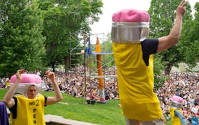 Dancers in pencil costumes celebrate with the crowd during the 4th Annual Lake of the Isles Pencil Sharpening in Minneapolis, Minn. on Saturday, June