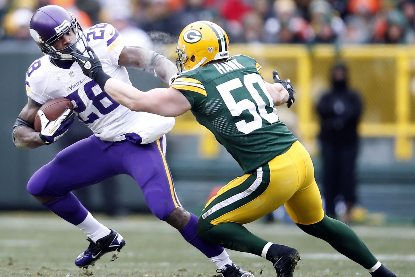 A.J. Hawk (50) reached at the facemask of Vikings running back Adrian Peterson (28) in the second quarter. Peterson fumbled the ball on the play. ] CARLOS GONZALEZ cgonzalez@startribune.com - November 24, 2013, Lambeau Field, Green Bay, WI, NFL, Minnesota Vikings vs. Green Bay Packers ORG XMIT: MIN1311241608362465