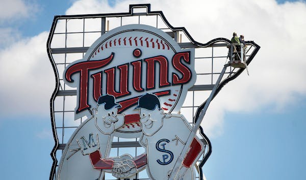Minnie and Paul embrace in the Target Field outfield, celebrating the rivalry between the Twin Cities.