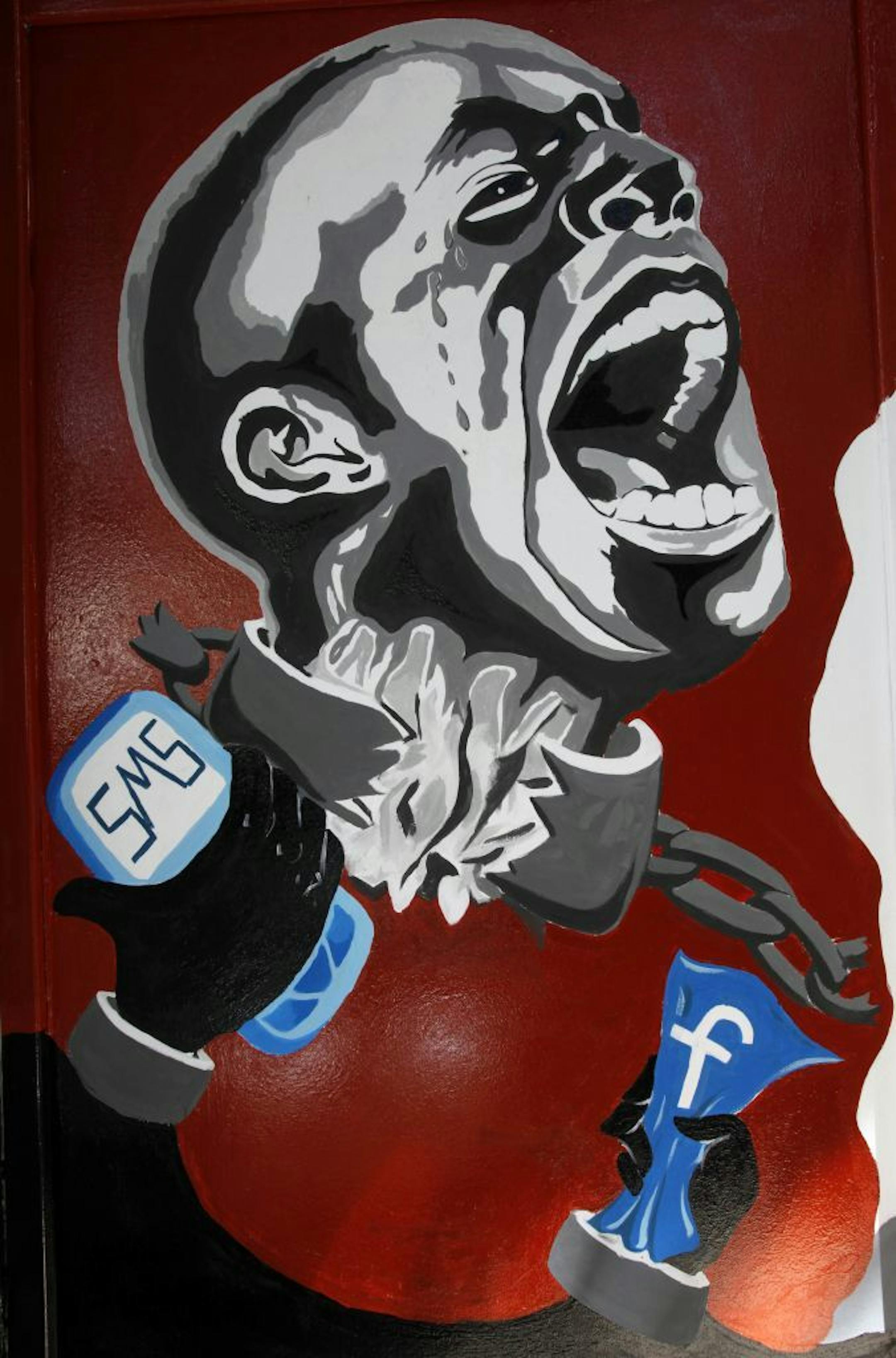 FILE - In this March 30, 2011, file photo, a mural depicting a man in shackles and the Facebook logo and a mobile phone is seen on the wall of the University of Helwan arts academy in the Zamalek neighborhood of Cairo, Egypt. The staunchly pro-government Egyptian parliament passed a bill Monday, July 16, 2018, targeting popular social media accounts that authorities accuse of publishing "fake news," the latest move in a five-year-old drive to suppress dissent and silence independent sources of n