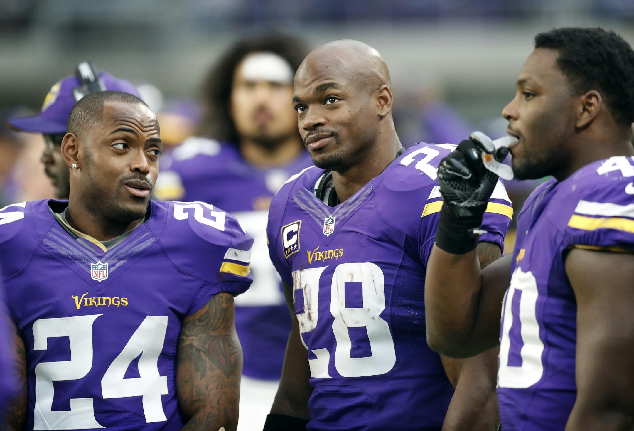 Minnesota Vikings cornerback Captain Munnerlyn (24), left running back Adrian Peterson (28).