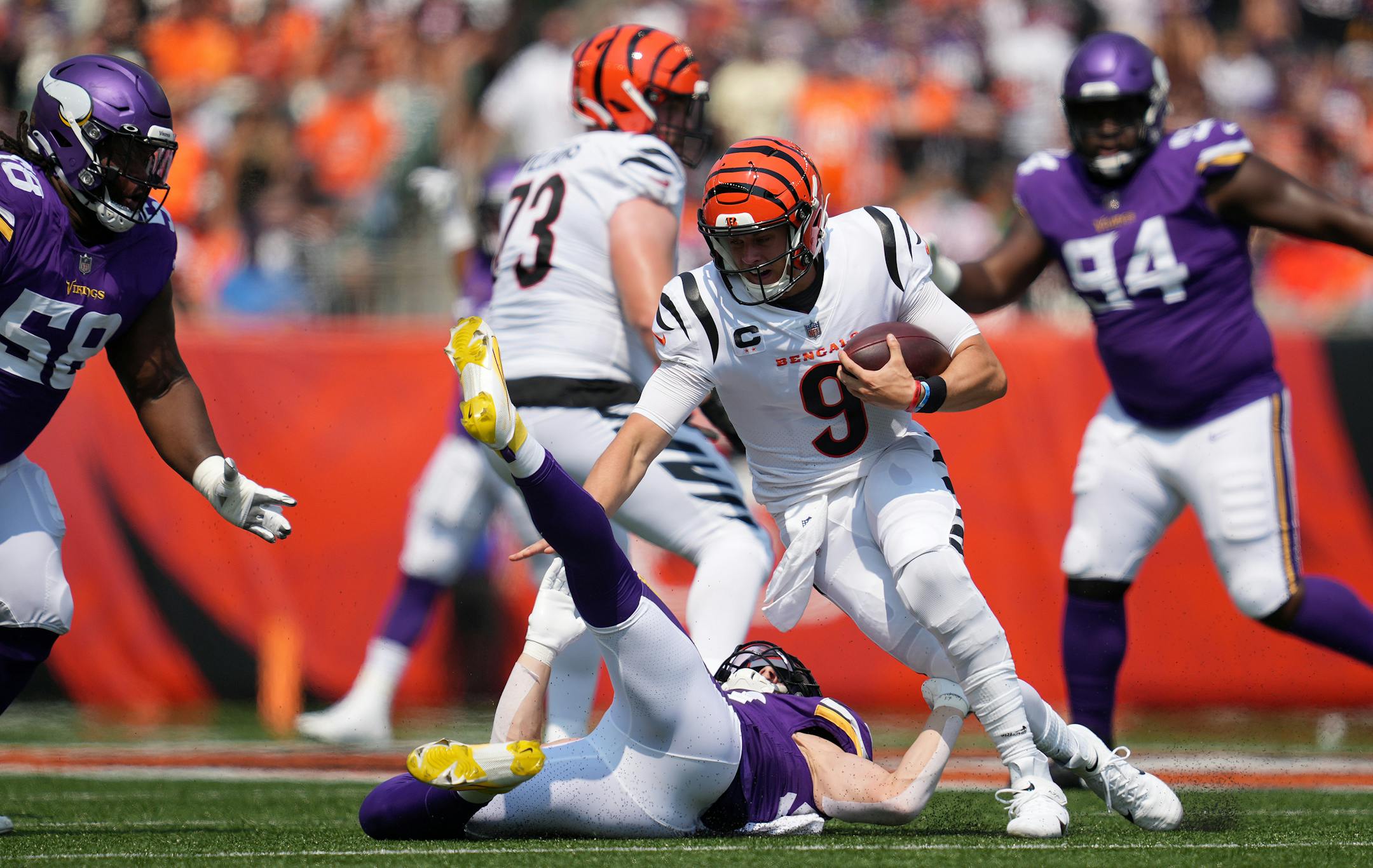 Cincinnati Bengals quarterback Joe Burrow (9) lost his footing as he scrambled out of the pocket away from Minnesota Vikings outside linebacker Nick Vigil (59) in the first quarter.