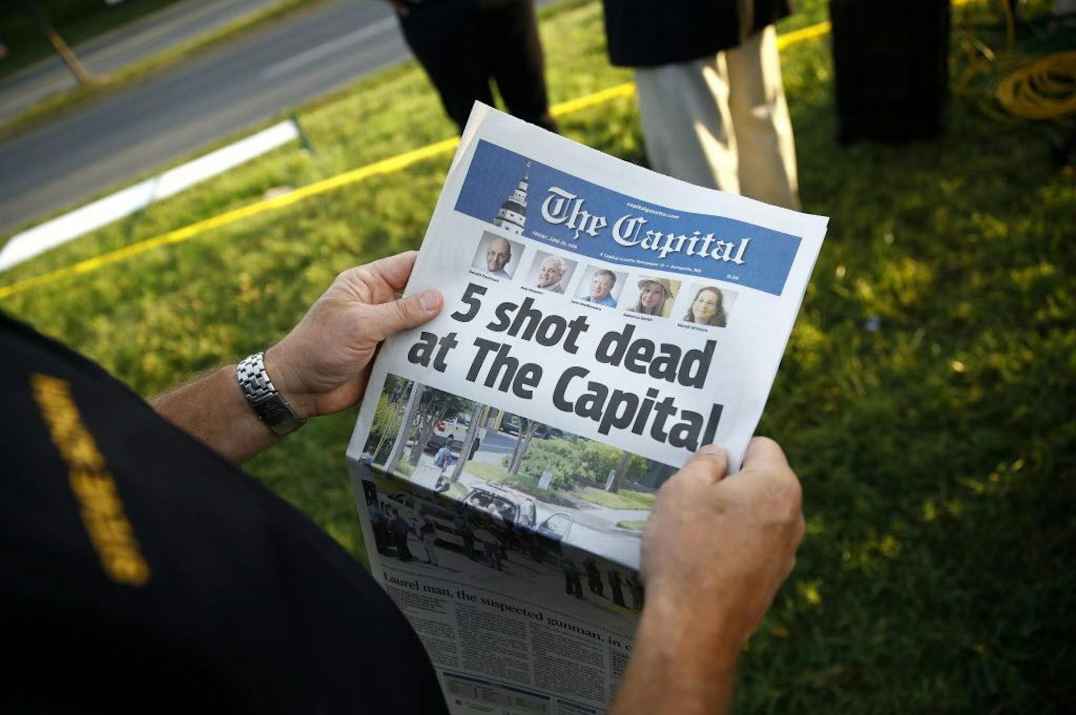 Steve Schuh, county executive of Anne Arundel County, holds a copy of The Capital Gazette near the scene of a shooting at the newspaper's office, Friday, June 29, 2018, in Annapolis, Md. A man armed with smoke grenades and a shotgun attacked journalists in the building Thursday, killing several people before police quickly stormed the building and arrested him, police and witnesses said.