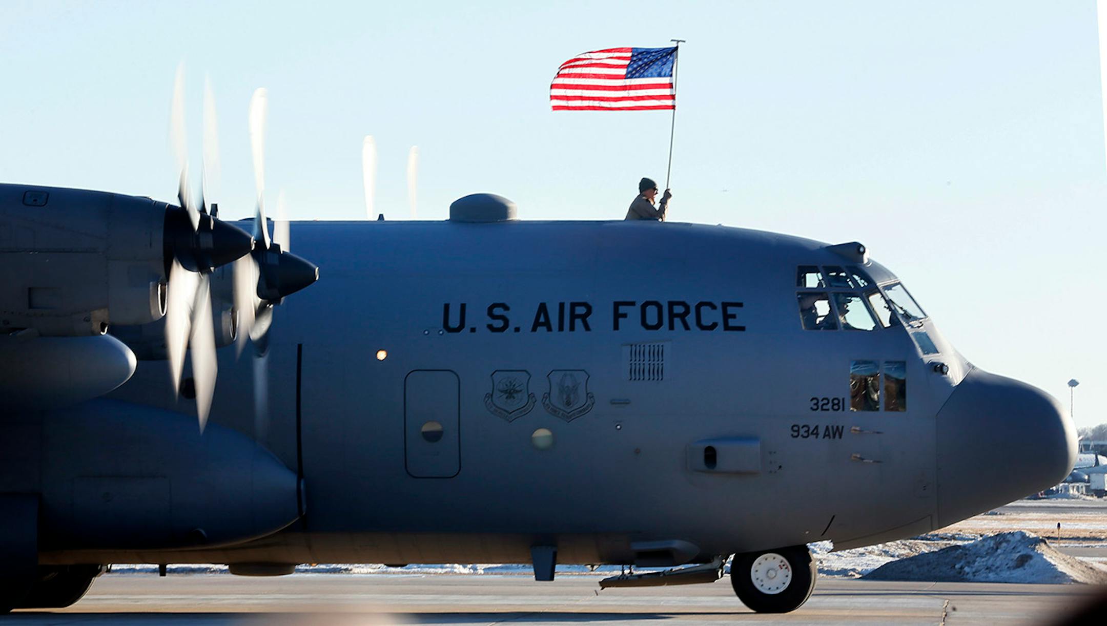 Senior Airman Brian Beckmann held the US flag as his unit arrived back in Minneapolis. Families gather for the arrival of the more than 100 Airmen and three C-130 H3 Hercules aircraft from the 934th Airlift Wing, Air Force Reserve, return from their deployment to Southwest Asia after their four-month tour of duty. Sunday January 18, 2015 Minneapolis, MN.] Jerry Holt/ Jerry.Holt@Startribune.com