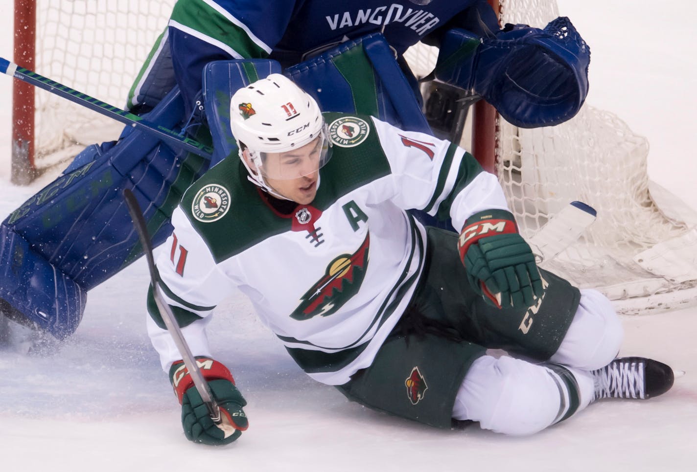 Minnesota Wild left wing Zach Parise (11) slides against Vancouver Canucks goaltender Anders Nilsson (31) during the third period of an NHL hockey game Friday, March 9, 2018, in Vancouver, British Columbia. (Jonathan Hayward/The Canadian Press via AP)